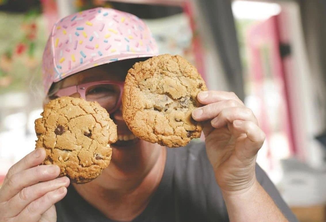 Reba holding up two cookies